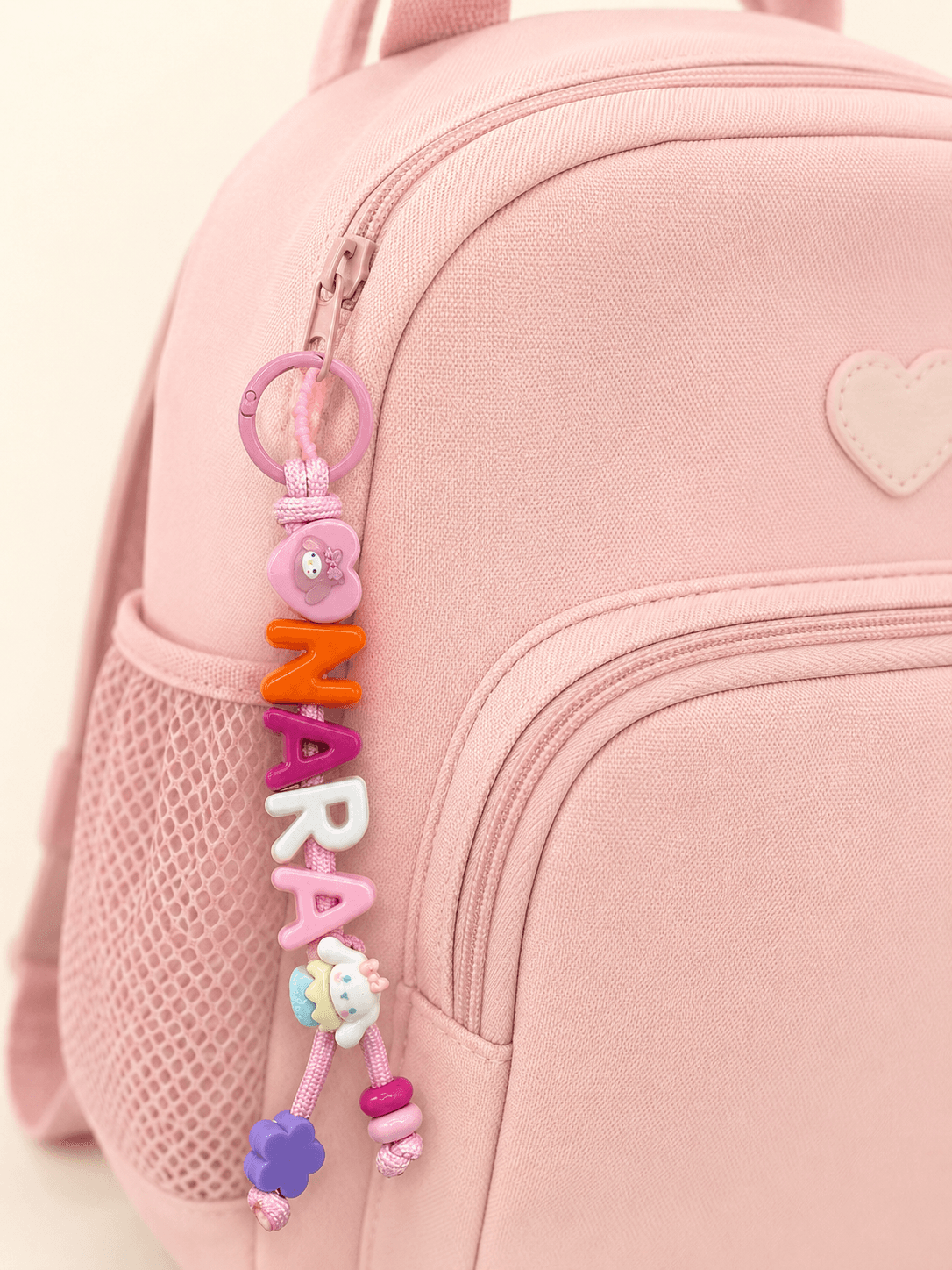 Custom keyring spelling ZARA on a pink backpack