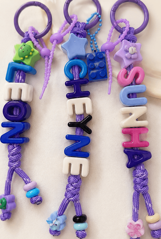 Three handmade custom alphabet keyrings spelling LEONZ, CHEYNE, and SUZIA