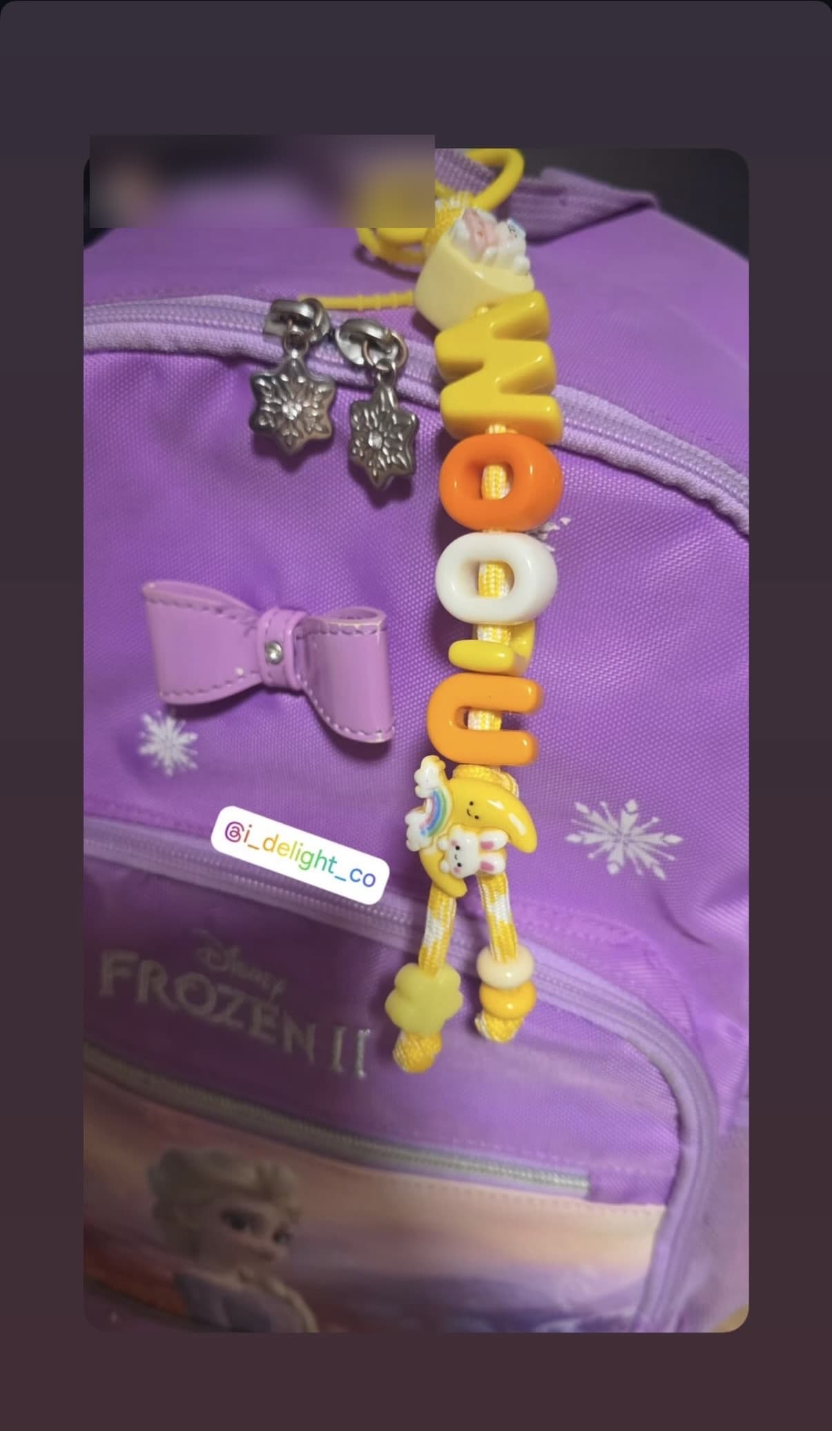 Custom keyring spelling WOOJU and NARA held up outdoors